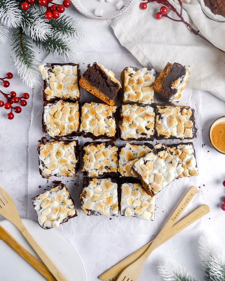 16 square smore's brownies from above with holly and berries on a white tablecloth