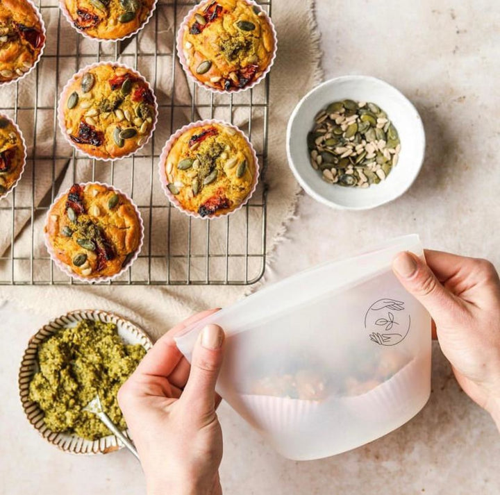 Savoury muffins cooling on a rack and being packed up in a silicone pouch.
