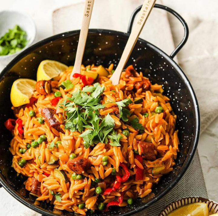 Orzo Paella in a pan with bamboo cutlery