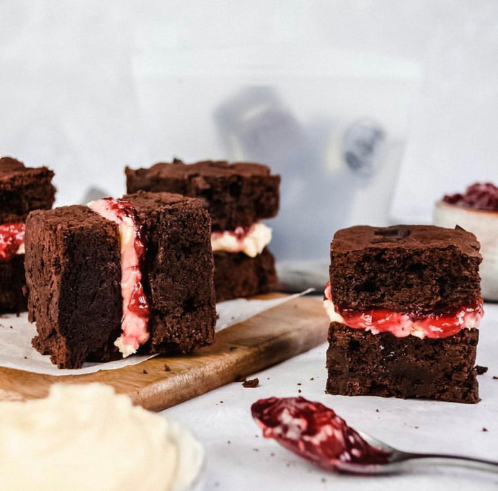 Brownie squares filled with jam and cream.