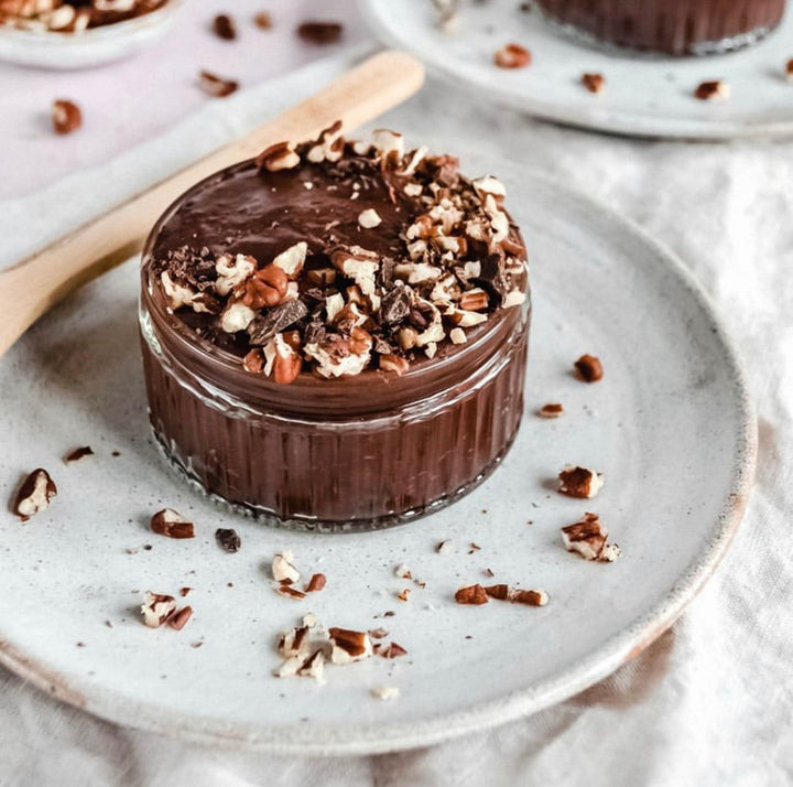 A ramekin of dark chocolate mousse topped with chopped nuts