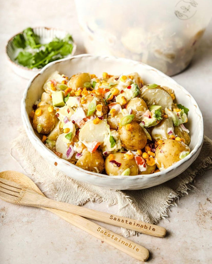 Bowl of potato salad with bamboo cutlery and silicone pouch