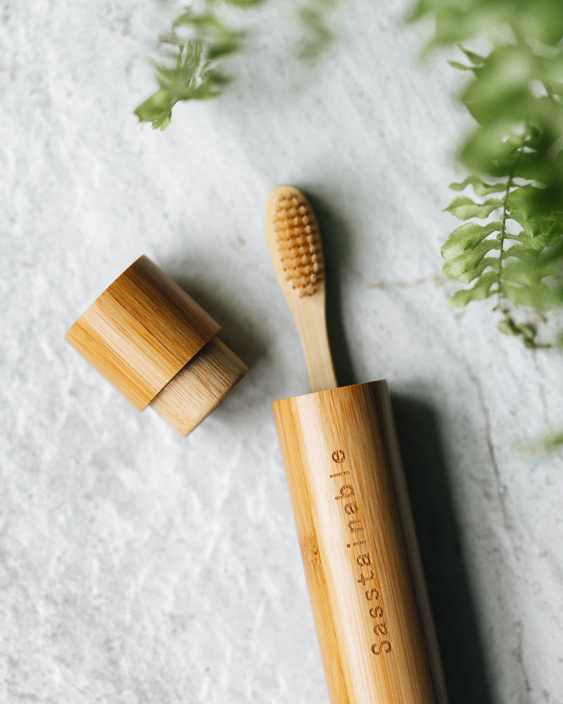 Bamboo toothbrush peeking out of bamboo tube