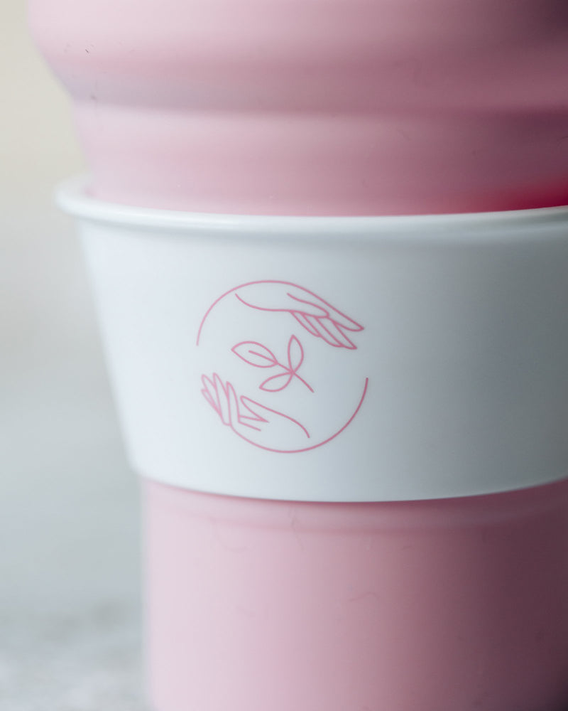 Close up of pink Sasstainable logo on the white cup collar.