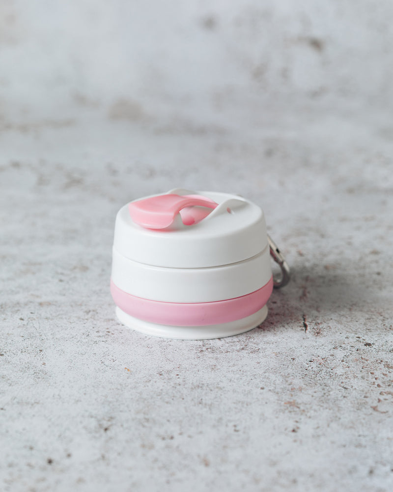 Collapsed pink and white silicone cup on a marble surface.