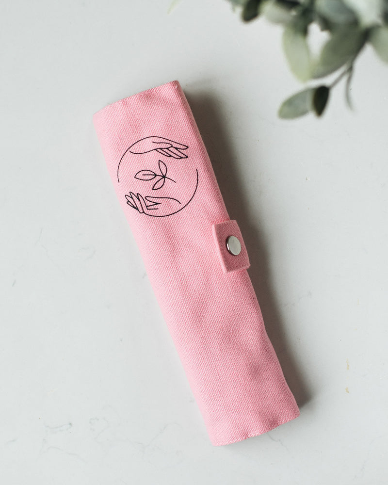 Rolled up pink canvas case, featuring Sasstainable logo