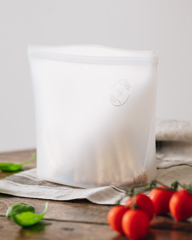 Large silicone pouch containing a sandwich with tomatoes in the foreground