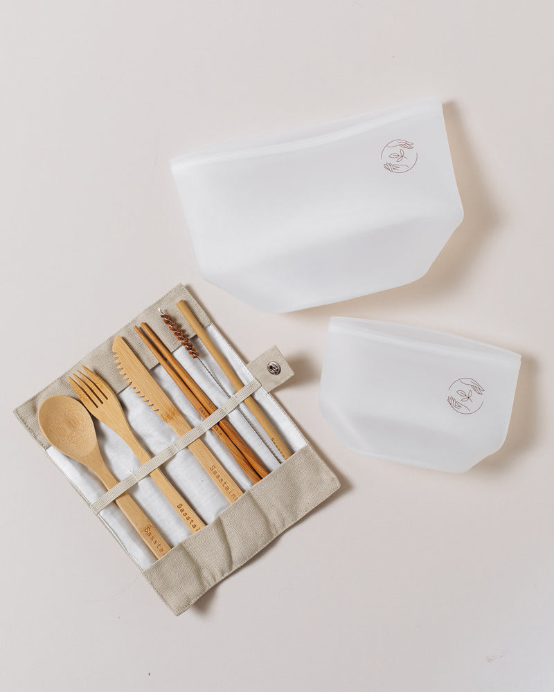 Large silicone pouch, small silicone pouch and open natural bamboo cutlery set on a plain white background.
