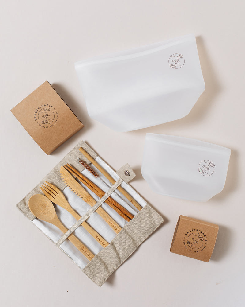 Large silicone pouch, small silicone pouch and open natural bamboo cutlery set on a plain white background.