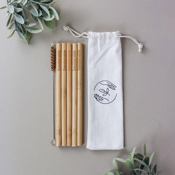 A straw cleaner and 5 bamboo straws with the word 